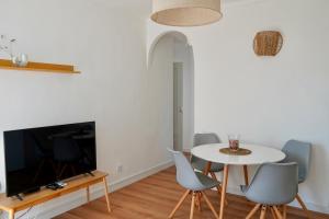 ein Esszimmer mit einem Tisch und Stühlen sowie einem TV in der Unterkunft Lavendel Apartments in Colonia Sant Jordi