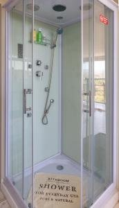 y baño con ducha y puerta de cristal. en AYRES SUITE en Villa Carlos Paz
