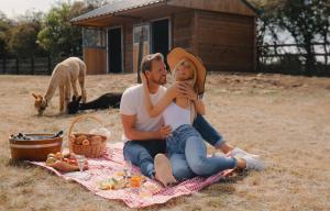 un homme et une femme assis sur une couverture de pique-nique dans l'établissement Domaine Des Hautes Fagnes, à Ovifat