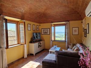 ein Wohnzimmer mit einem Sofa und 2 Fenstern in der Unterkunft Peccioli - The Tuscany Nest in Peccioli
