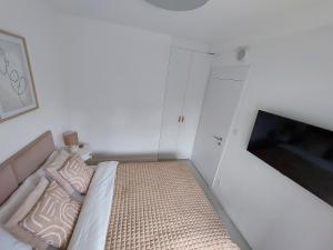 Habitación blanca pequeña con cama y TV en Harmony Pearl Apart, en Rogowo