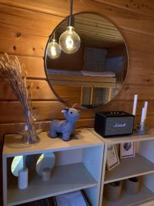 a small blue teddy bear sitting on a shelf under a mirror at Villa Aiku in Leppäjärvi