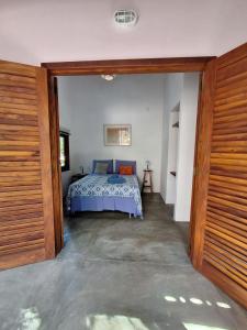 1 dormitorio con 1 cama y puerta de madera en Casa Papa-Vento en Lençóis