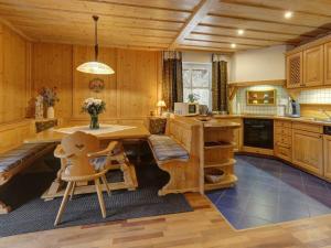 a kitchen with wooden cabinets and a table and chairs at Waldhaus Sonnenberg Apartment 3 in Drachselsried