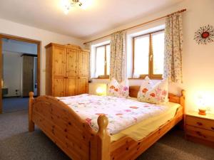 a bedroom with a wooden bed and two windows at Ziegler 2 Modern retreat in Berchtesgaden