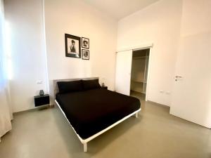 um quarto com uma cama preta num quarto branco em Al Mulein F em SantʼAgata Bolognese