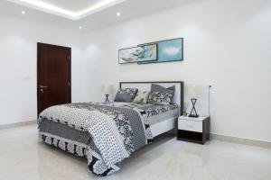 a white bedroom with a bed and a picture on the wall at Residence Zeyna Ngor Almadies, Dakar, Senegal- Appart 3 chambres, 3 salles de bain in Dakar