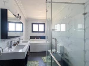 a white bathroom with a sink and a shower at Residence Mandela Almadies Dakar, Senegal, Ngor Almadies in Ngor