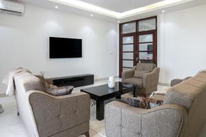 a living room with two couches and a tv at Residence Mandela Almadies Dakar, Senegal, Ngor Almadies in Ngor
