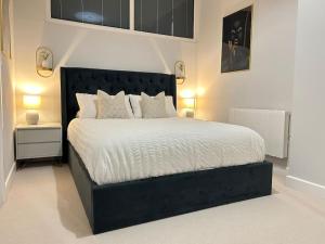 a bedroom with a large bed with white sheets and pillows at Trendy City Centre Apartment with FREE Parking in Southampton