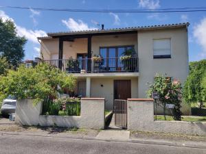 a house with a balcony on a street at 2 chambres dans maison familiale in Le Passage