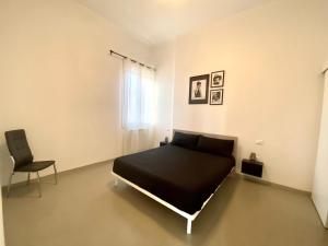 a bedroom with a black bed and a chair at Al Mulein F in SantʼAgata Bolognese