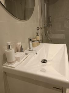 ein Badezimmer mit einem weißen Waschbecken und einem Spiegel in der Unterkunft Apartman 4* Ester in Rovinj