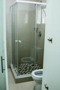 a bathroom with a glass shower with a toilet at BOTHA VILLA LODGE in Cape Town