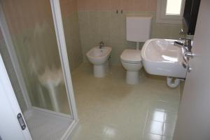 een badkamer met een toilet, een wastafel en een douche bij Hotel Helga in Caorle