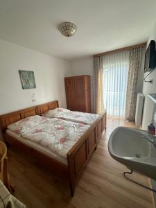sypialnia z łóżkiem i umywalką w obiekcie Leo's Pension w mieście Bad Schallerbach