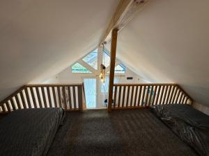 a attic bedroom with two beds and a large window at La Casute in Jurilovca