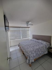 1 dormitorio con cama y ventana grande en Casa Denali en Aguascalientes