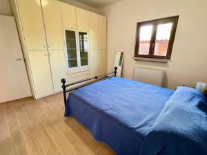 Un dormitorio con una cama con una manta azul. en Il Glicine di Luna, en Torrimpietra