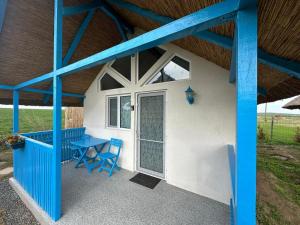 a patio with a blue table and a door at La Casute in Jurilovca