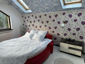 um quarto com uma cama com papel de parede floral em Vila Babylon em Predeal