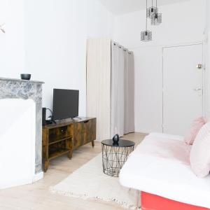 ein weißes Wohnzimmer mit einem Sofa und einem TV in der Unterkunft T2 à 5 min de la GARE , CENTRALE et LUMINEUX in Marseille