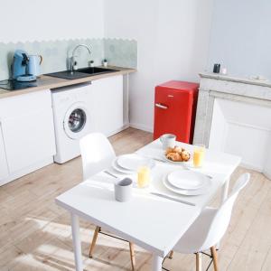 einen weißen Tisch und Stühle in einer Küche mit Spüle in der Unterkunft T2 à 5 min de la GARE , CENTRALE et LUMINEUX in Marseille