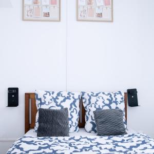 Schlafzimmer mit einem Bett mit blauen und weißen Kissen in der Unterkunft T2 à 5 min de la GARE , CENTRALE et LUMINEUX in Marseille