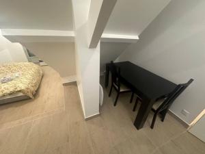 un tavolo e una sedia neri in una stanza con un letto di Studio dans une maison 2/3 ad Aulnay-sous-Bois
