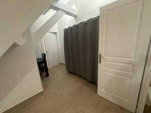 un corridoio con una porta bianca e una fila di bancarelle di Studio dans une maison 2/3 ad Aulnay-sous-Bois