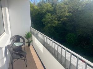 a balcony with two chairs and a large window at Apartament Nati in Cieszyn