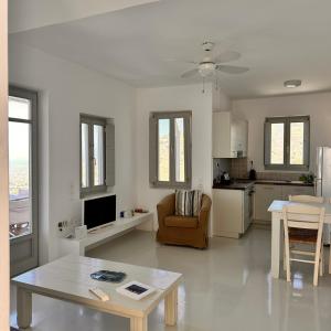 a living room with a table and a kitchen at AEGEAN WINGS MAISONETTE in Ioulida