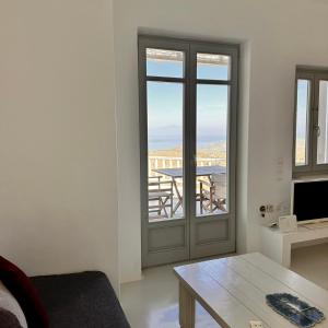 a living room with a door and a table at AEGEAN WINGS MAISONETTE in Ioulida