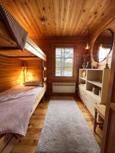 ein Schlafzimmer mit einem Bett in einer Holzhütte in der Unterkunft Villa Aiku in Leppäjärvi