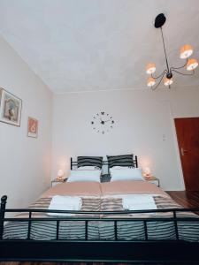 una camera da letto con un grande letto con un orologio sul muro di Dions Rooms a Norderney