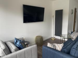 uma sala de estar com 2 sofás e uma televisão de ecrã plano em Inverness luxury highland NC500 hideaway em Inverness