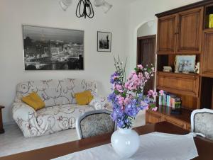 a living room with a couch and a vase with flowers at La Collina in Riccò del Golfo di Spezia