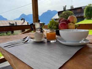 stół z miską owoców i miską soku w obiekcie Appartamento da Romano - nel cuore delle Dolomiti w mieście Danta