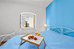 a bed with a tray of food and two glasses of orange juice at Old Tower Center Apartment in Pula