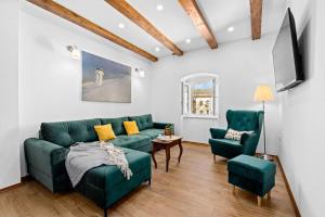 a living room with a green couch and two chairs at Old Tower Center Apartment in Pula