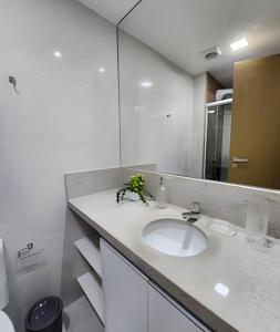 a bathroom with a sink and a mirror at H.E 704 · Comodidade no Caminho Das Árvores in Salvador