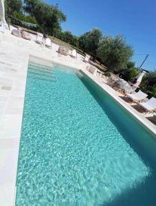 basen z błękitną wodą w ośrodku w obiekcie Trullo Perla Greta - Luxury Country Villa & private heated pool w Alberobello