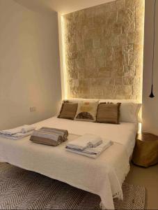 łóżko z ręcznikami w sypialni w obiekcie Trullo Perla Greta - Luxury Country Villa & private heated pool w Alberobello