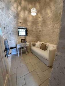 salon z kanapą i stołem w obiekcie Trullo Perla Greta - Luxury Country Villa & private heated pool w Alberobello