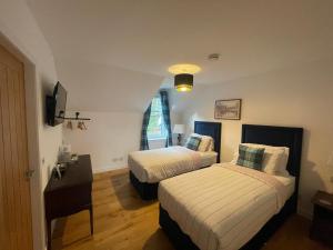 ein Hotelzimmer mit 2 Betten und einem Schreibtisch in der Unterkunft Crannach House in Ballater