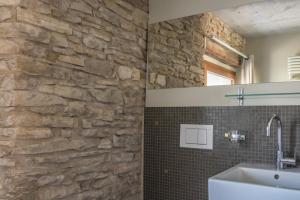 a bathroom with a stone wall and a sink at Le Paysan Horloger in Les Bois