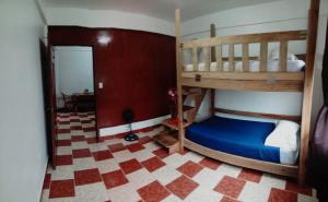 1 dormitorio con 2 literas y suelo a cuadros en Hostel Casa Verde, Tela Atlantida. en Tela