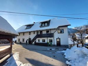 uma casa branca com neve no telhado em Apartmaji Hodnik Stara Fužina em Bohinj