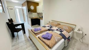 a bedroom with a bed with purple pillows on it at Henry Apartment Nesvady in Nesvady
