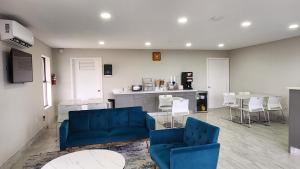 een woonkamer met twee blauwe stoelen en een tafel bij Scottish Inn & Suites in Wharton